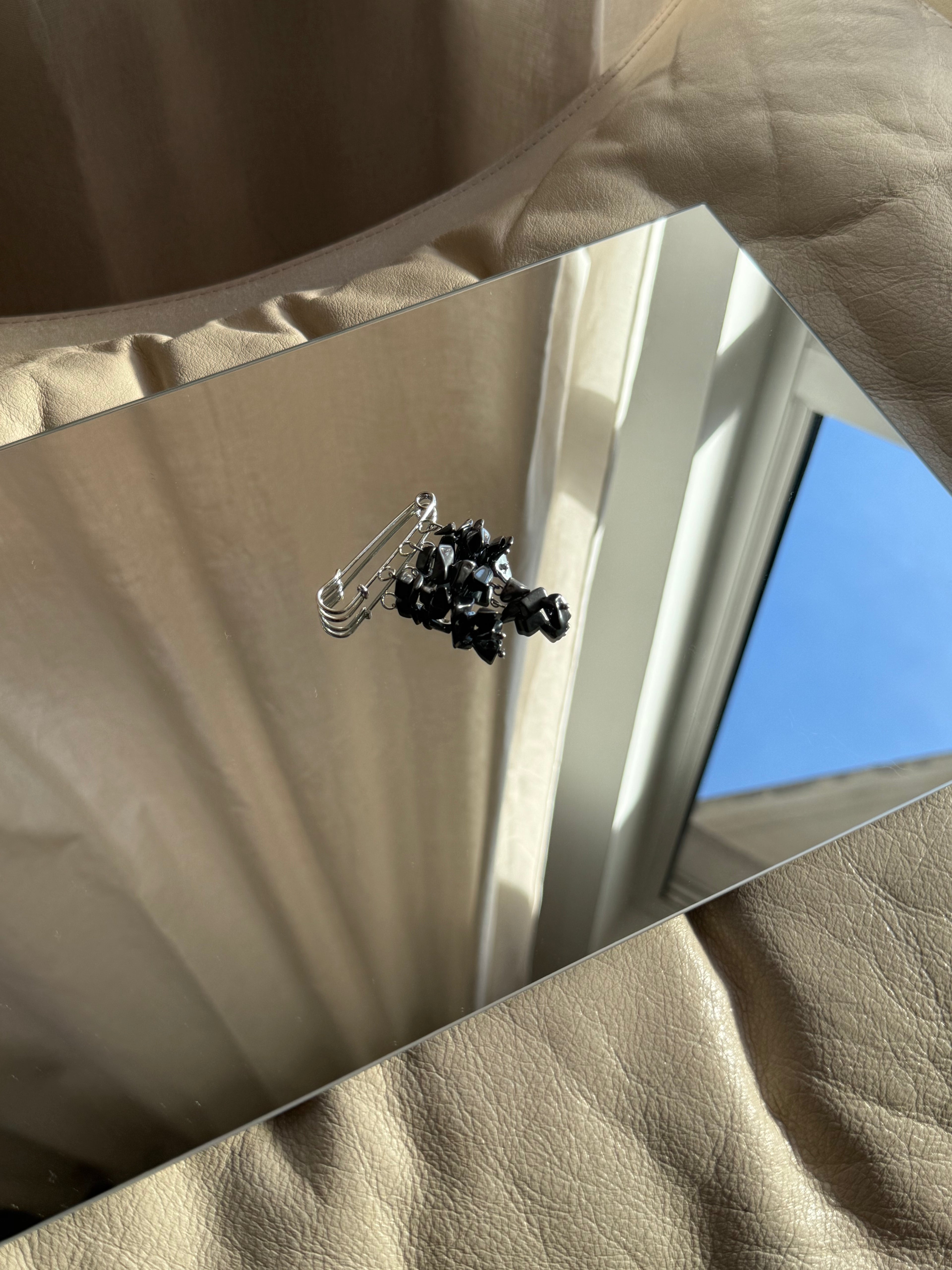 handgemachte mit Perlen verzierte Brosche in silber Nr.2 auf Spiegel